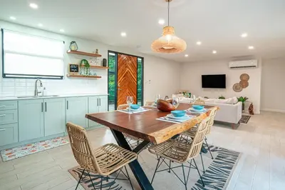 a kitchen and living room with a wooden table and chairs at Tropical 4BR Retreat with Private Pool Guest House in Tamarindo
