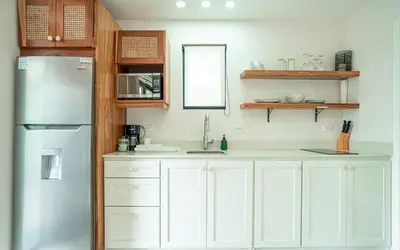 a kitchen with white cabinets and a stainless steel refrigerator at Tropical 4BR Retreat with Private Pool Guest House in Tamarindo