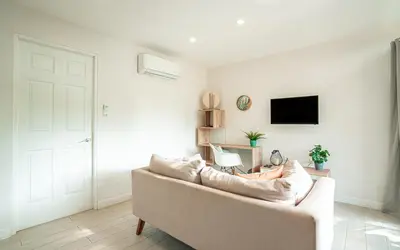 a white living room with a couch and a tv at Tropical 4BR Retreat with Private Pool Guest House in Tamarindo
