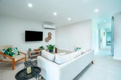 a living room with a white couch and a tv at Tropical 4BR Retreat with Private Pool Guest House in Tamarindo