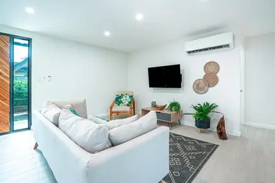 a living room with a white couch and a tv at Tropical 4BR Retreat with Private Pool Guest House in Tamarindo