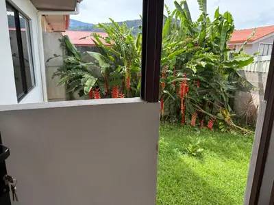 an open window with a view of a garden at Casa Tucán Turrialba in Turrialba