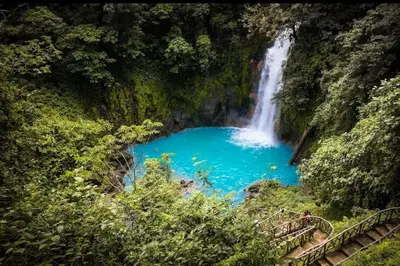 a waterfall in the middle of a blue pool of water at Hacienda Paraíso Rio Celeste 1 in Rio Celeste