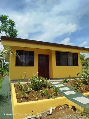 a yellow house with a walkway in front of it at Hacienda Paraíso Rio Celeste 1 in Rio Celeste