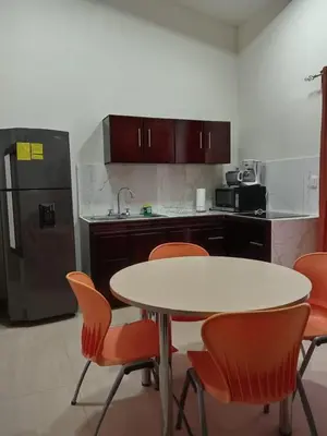 a kitchen with a table and chairs and a refrigerator at Hacienda Paraíso Rio Celeste 1 in Rio Celeste