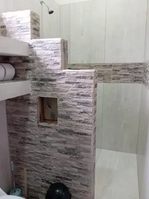 a bathroom with a stone wall and a shower at Hacienda Paraíso Rio Celeste 1 in Rio Celeste