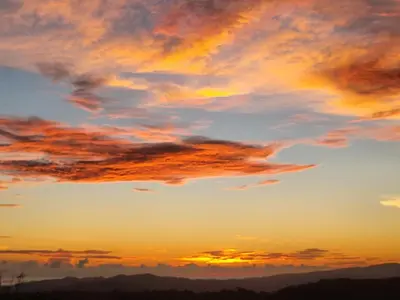 a sunset with clouds in the sky at Villa Milagro in Parrita