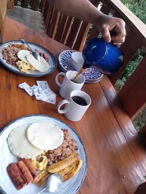 a table topped with plates of breakfast food and coffee at Ecos del Poás junto a la piscina in Alajuela City