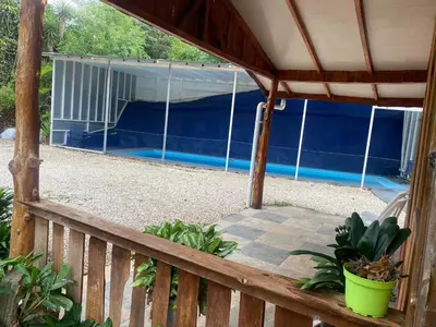 a deck with a canopy and a swimming pool at Ecos del Poás junto a la piscina in Alajuela City