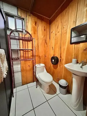 a bathroom with a toilet and a sink at Ecos del Poás junto a la piscina in Alajuela City