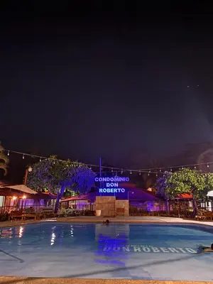 a swimming pool at night with a hotel at Sol y Mar Condominio don Roberto in Jacó