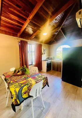 a dining room with a table and a kitchen at Apartamento con jardín privado in Coco
