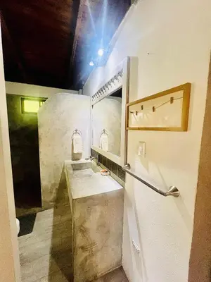 a bathroom with a sink and a mirror at Apartamento con jardín privado in Coco