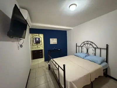 a bedroom with a bed and a flat screen tv at Casa Bela in Parrita