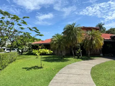 a walkway in front of a house with palm trees at Casa Bela in Parrita