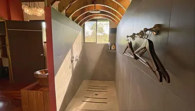 a bathroom with a bench in the corner of a room at Mei Tai Cacao Lodge in Bijagua