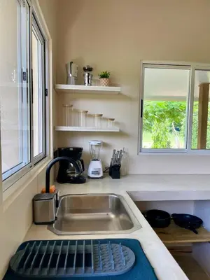 a kitchen with a sink and a window at Teva Guest House with Shared pool in Cabuya