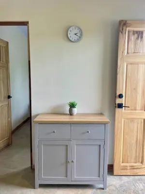 a white cabinet with a clock on a wall at Teva Guest House with Shared pool in Cabuya