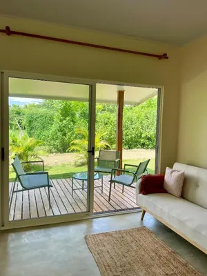 a living room with a couch and chairs on a deck at Teva Guest House with Shared pool in Cabuya
