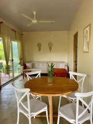 a living room with a table and chairs and a couch at Teva Guest House with Shared pool in Cabuya