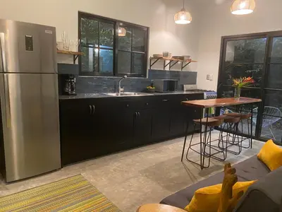 a kitchen with a stainless steel refrigerator and a table at Private Cabina at Yoga Center in Ojochal