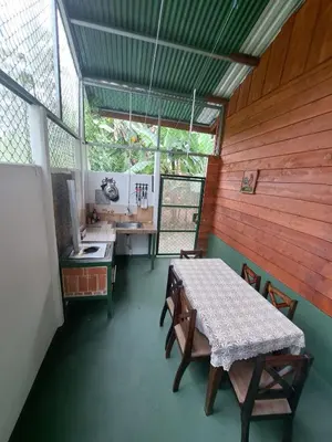 a room with a table and chairs and a kitchen at Cabin in Orosi in Orosí