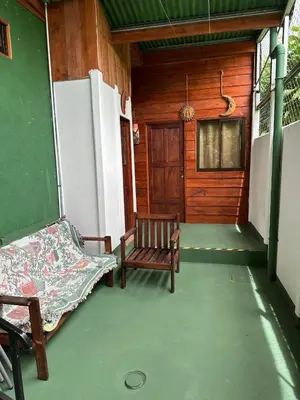 a porch of a house with a bench and a door at Cabin in Orosi in Orosí