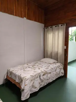 a small bed in a room with a window at Cabin in Orosi in Orosí