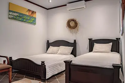 two beds sitting next to each other in a room at Villa Azulita in Tarcoles