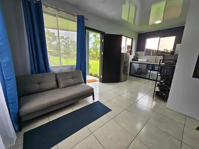 a living room with a couch and a kitchen at Casa Vista Arenal in Fortuna
