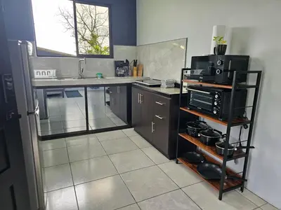 a kitchen with a sink and a microwave at Casa Vista Arenal in Fortuna