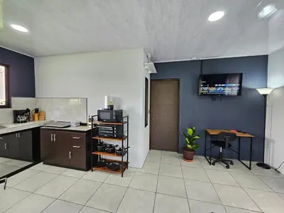 a kitchen with a counter and a table and a desk at Casa Vista Arenal in Fortuna