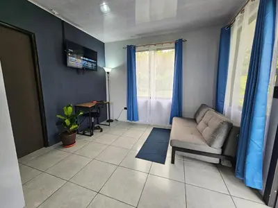 a living room with a couch and a table at Casa Vista Arenal in Fortuna