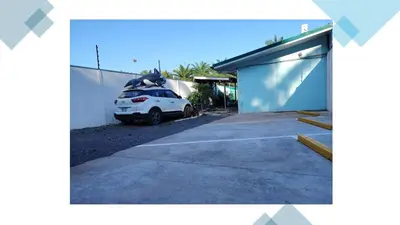 a car parked in a parking lot next to a building at Villa Blue Vacations in Parrita