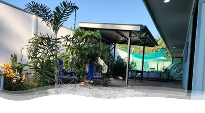 a patio with blue chairs and plants in a building at Villa Blue Vacations in Parrita