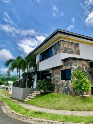 a house with a stone facade and palm trees at Near from Beach- Cozy Herradura Tropical home in Herradura
