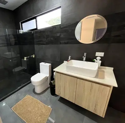 a bathroom with a sink and a toilet and a mirror at Near from Beach- Cozy Herradura Tropical home in Herradura