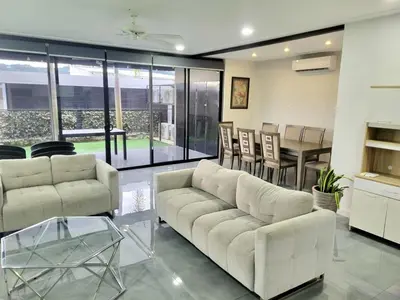 a living room with a white couch and a table at Near from Beach- Cozy Herradura Tropical home in Herradura