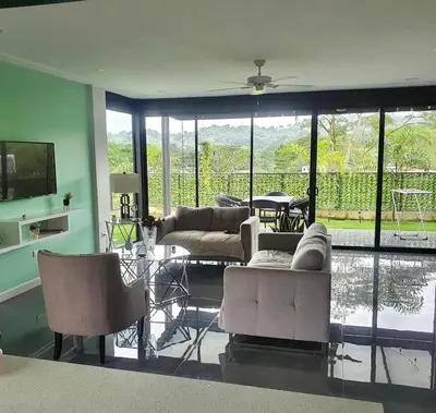 a living room with couches and chairs and a television at Near from Beach- Cozy Herradura Tropical home in Herradura