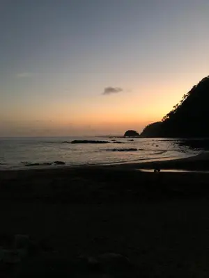 a person walking on the beach at sunset at Near from Beach- Cozy Herradura Tropical home in Herradura