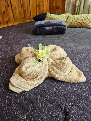 a towel with a flower on a bed at Ecos del Poás vista al jardín in Dulce Nombre