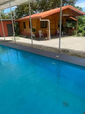 a blue swimming pool in front of a house at Ecos del Poás vista al jardín in Dulce Nombre