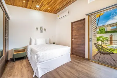 a bedroom with a bed and a sliding glass door at Macondo Ecolodge Apt 4 - Estrella de Fuego in Coco