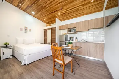 a bedroom with a bed and a table and a kitchen at Macondo Ecolodge Apt 3 - Guaria Morada in Coco