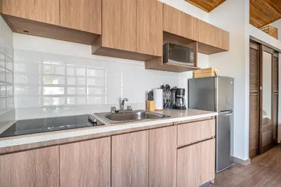 a kitchen with a sink and a stainless steel refrigerator at Macondo Ecolodge Apt 2 - Bromelia in Coco