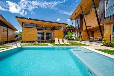 a swimming pool in front of a house at Macondo Ecolodge Apt 5 - Alpinias in Coco
