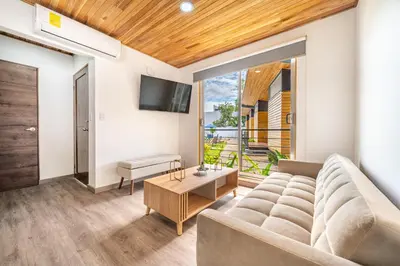 a living room with a couch and a tv at Macondo Ecolodge Apt 5 - Alpinias in Coco