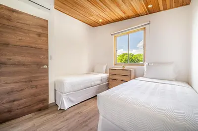 a bedroom with two beds and a window at Macondo Ecolodge Apt 5 - Alpinias in Coco