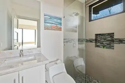 a bathroom with a toilet and a sink and a shower at Serene Oceanview Villa with Pool in Playa Flamingo