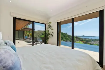 a bedroom with a bed with a view of the ocean at Serene Oceanview Villa with Pool in Playa Flamingo